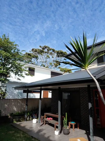 A home with a veranda set among established trees