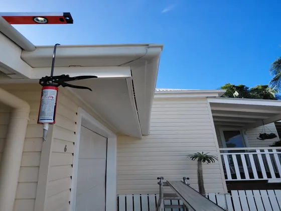 A spirit level checking the fall on a newly installed gutter